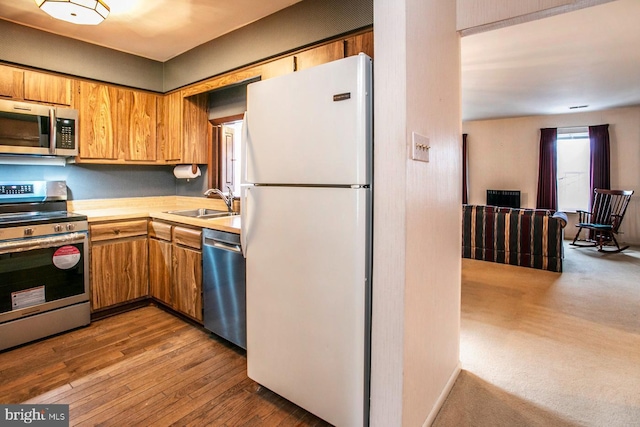 kitchen featuring appliances with stainless steel finishes, sink, and hardwood / wood-style floors