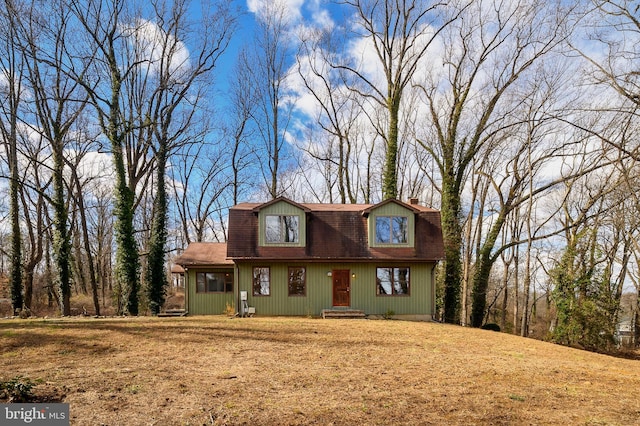 cape cod home featuring a front lawn