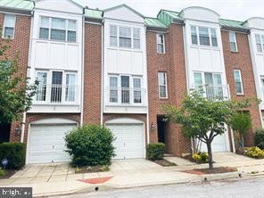 townhome / multi-family property featuring an attached garage, concrete driveway, and brick siding