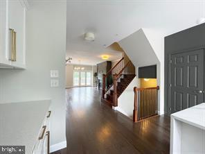 kitchen with dark wood-type flooring and white cabinets