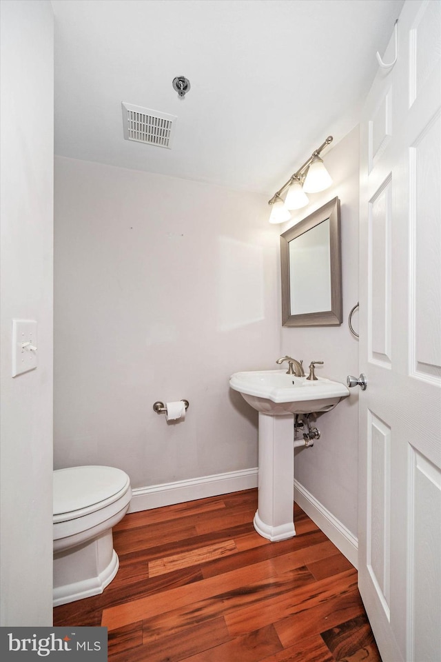 bathroom featuring wood-type flooring, sink, and toilet