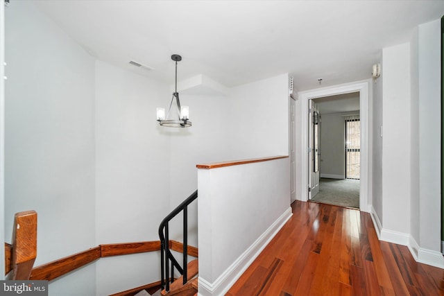 corridor featuring a notable chandelier and hardwood / wood-style flooring