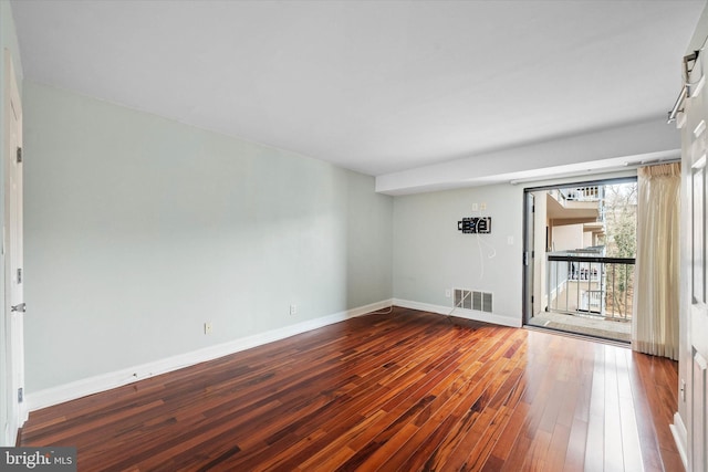 spare room with baseboards, visible vents, and hardwood / wood-style floors