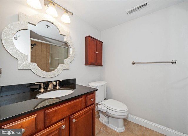 bathroom featuring vanity, tile patterned floors, toilet, and walk in shower