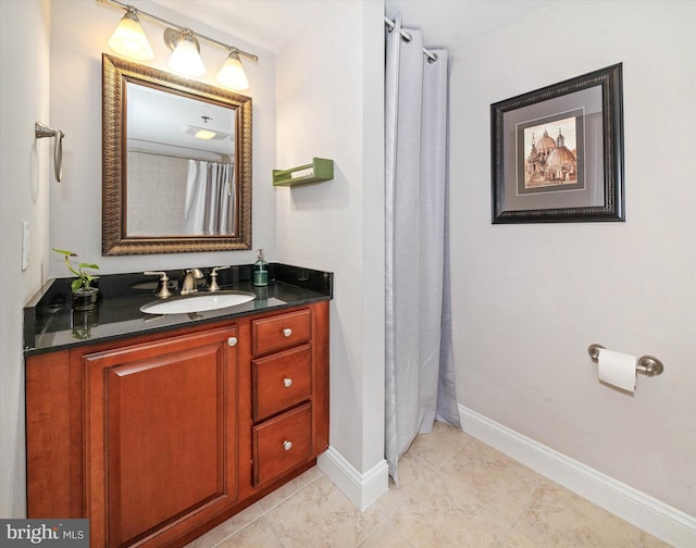 full bathroom with vanity and baseboards