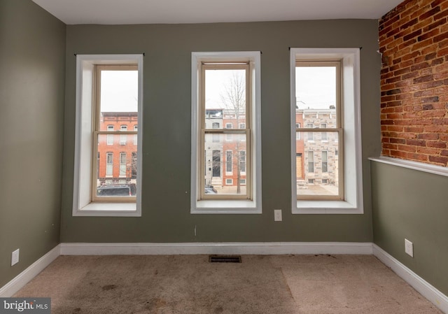 spare room featuring a healthy amount of sunlight and carpet floors