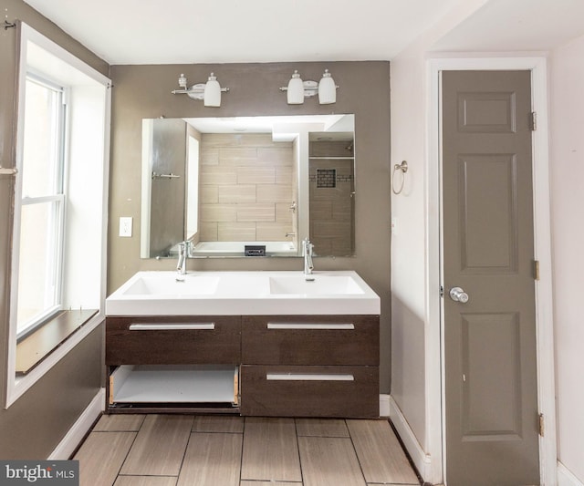 bathroom with vanity, plenty of natural light, and tiled shower