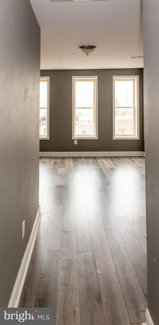 unfurnished room featuring hardwood / wood-style flooring and plenty of natural light