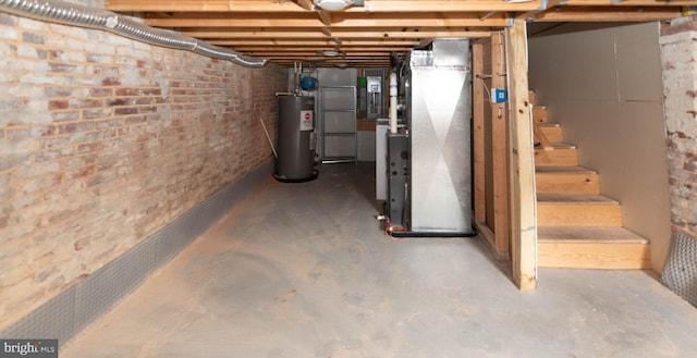 basement featuring brick wall, electric water heater, heating unit, and electric panel