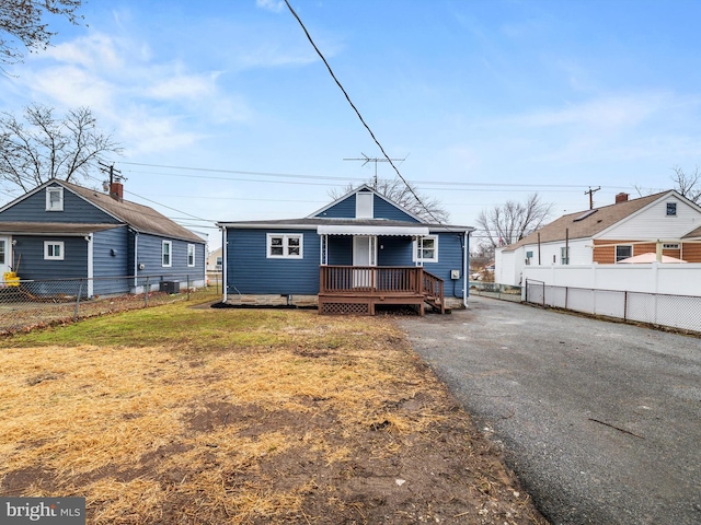 bungalow-style house featuring a wooden deck and a front lawn