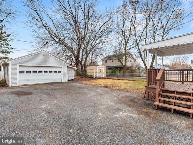 view of yard with a garage, a wooden deck, and a shed