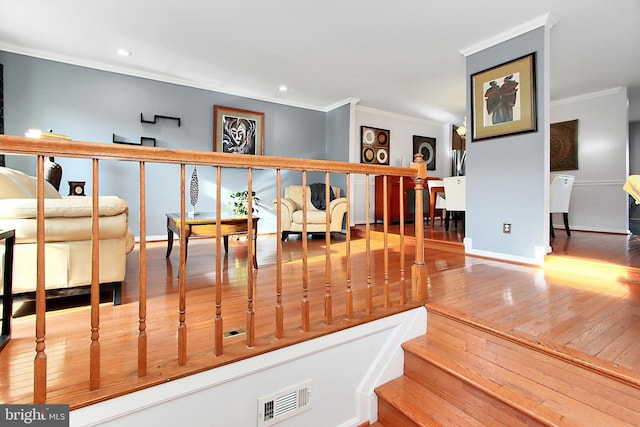 stairway featuring wood-type flooring and ornamental molding