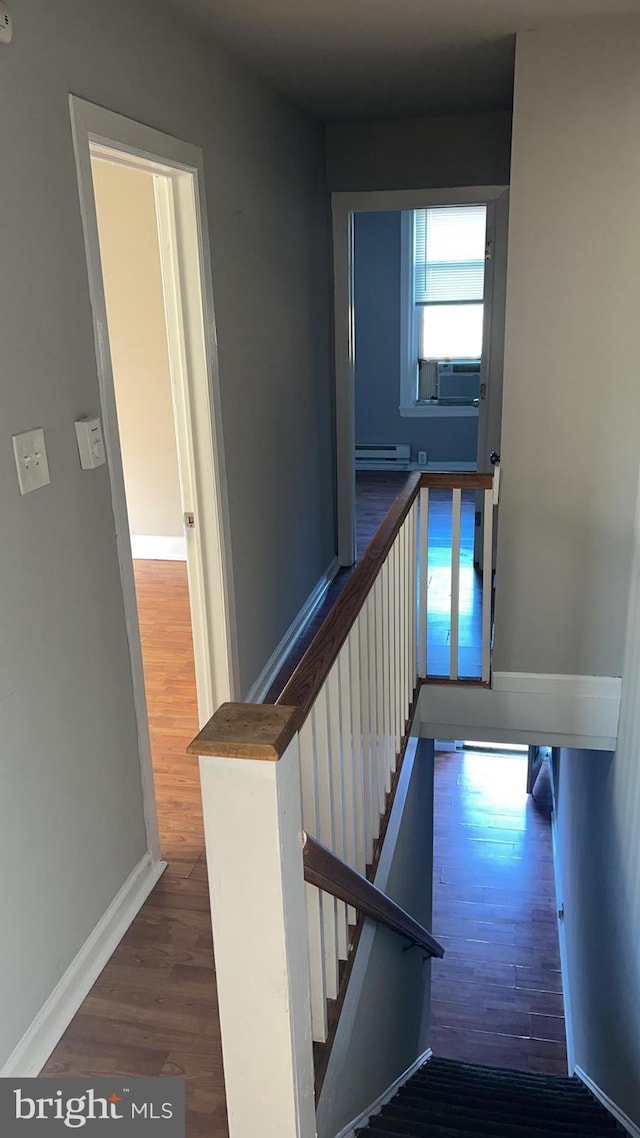 stairway with cooling unit, hardwood / wood-style flooring, and a baseboard radiator