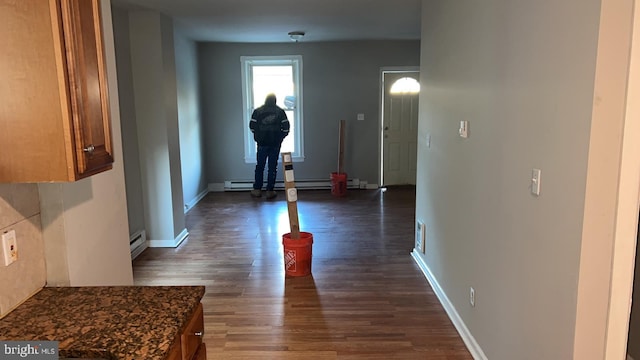 hallway featuring a baseboard heating unit and dark hardwood / wood-style floors