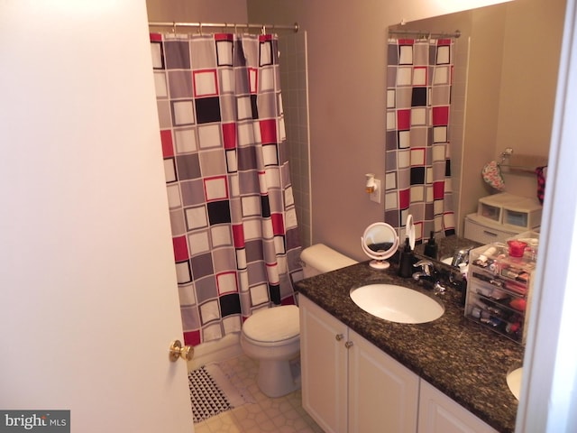 bathroom with vanity, curtained shower, and toilet