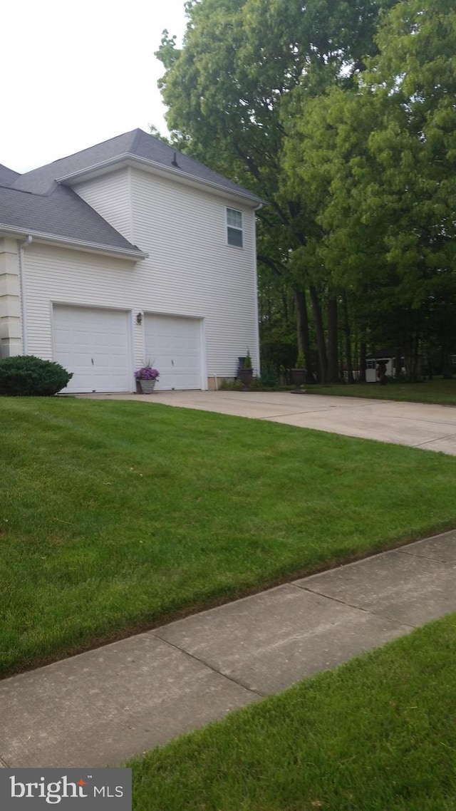 view of property exterior with a garage and a yard