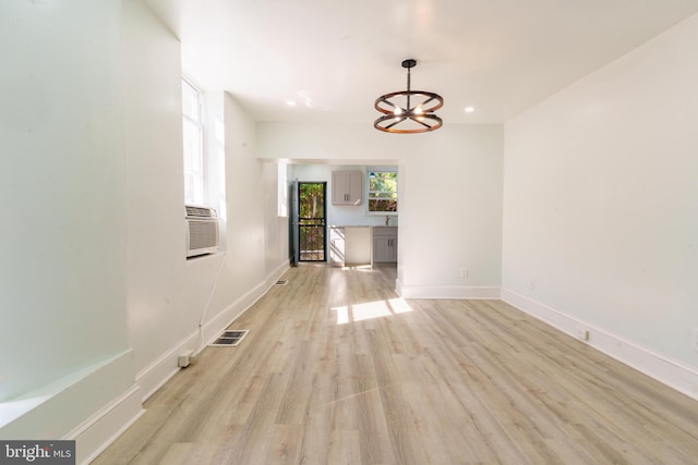 unfurnished dining area featuring cooling unit and light wood-type flooring