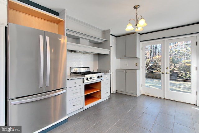 kitchen with appliances with stainless steel finishes, pendant lighting, white cabinets, backsplash, and light stone counters