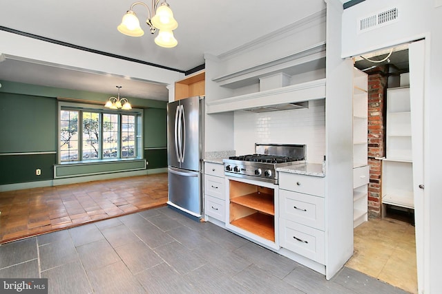 kitchen with hanging light fixtures, appliances with stainless steel finishes, a notable chandelier, light stone countertops, and white cabinets