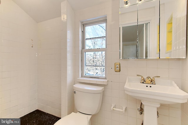 bathroom with tasteful backsplash, lofted ceiling, toilet, and tile walls