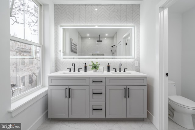 bathroom with vanity, backsplash, toilet, and walk in shower