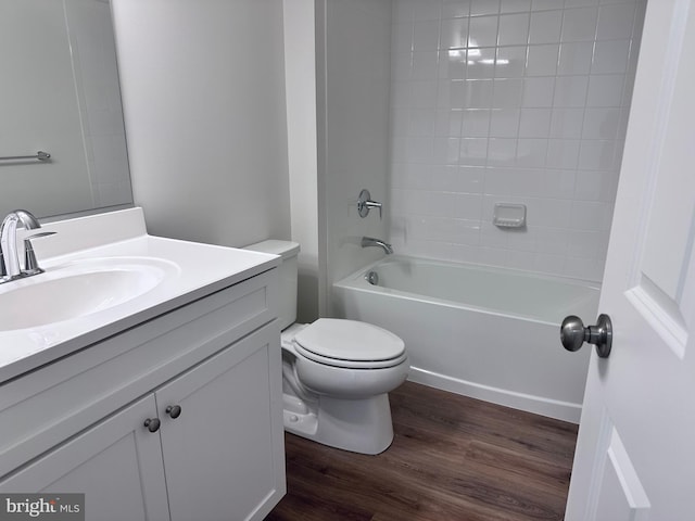 full bathroom featuring wood-type flooring, toilet, tiled shower / bath combo, and vanity