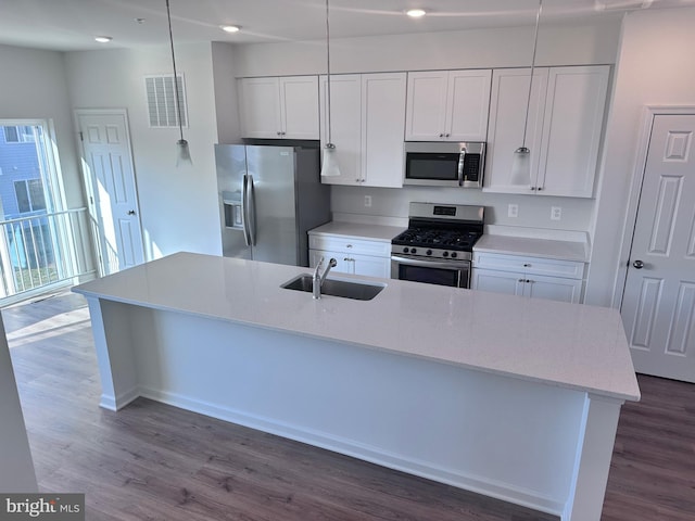 kitchen featuring stainless steel appliances, white cabinets, and decorative light fixtures