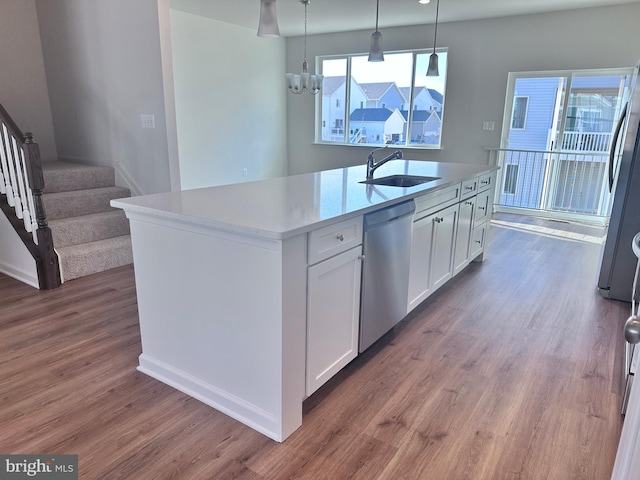 kitchen featuring sink, a kitchen island with sink, hanging light fixtures, white cabinetry, and stainless steel appliances