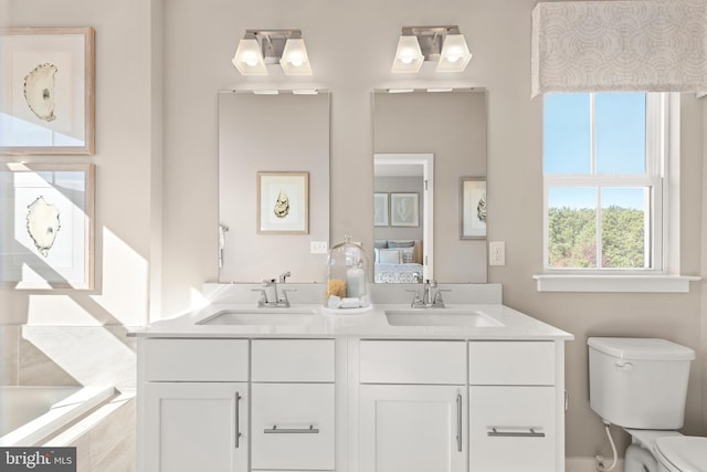 bathroom featuring a relaxing tiled tub, vanity, and toilet