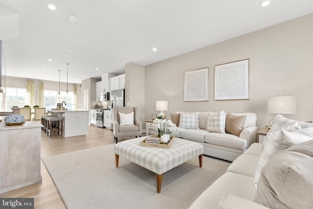 living room with sink and light hardwood / wood-style flooring