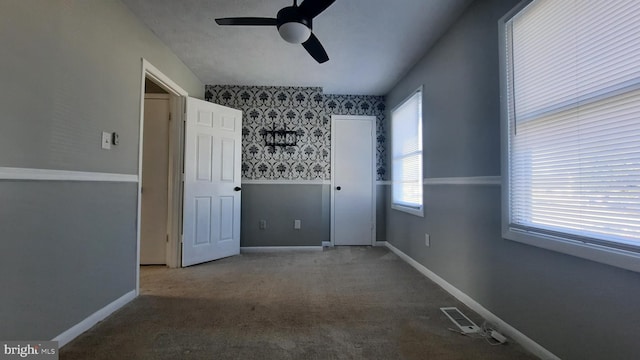 carpeted empty room featuring ceiling fan