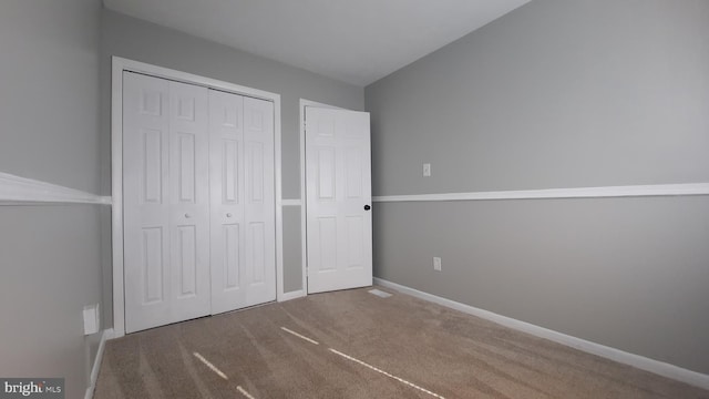 unfurnished bedroom with a closet and carpet flooring