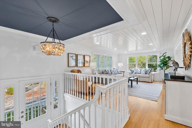 corridor featuring an inviting chandelier, crown molding, wooden ceiling, and light wood-type flooring