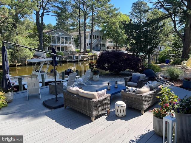 wooden terrace with an outdoor hangout area and a water view