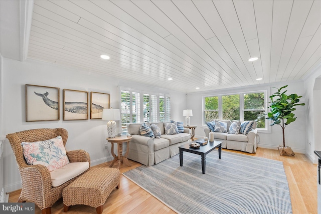 living room featuring a healthy amount of sunlight, wood ceiling, and light wood-type flooring