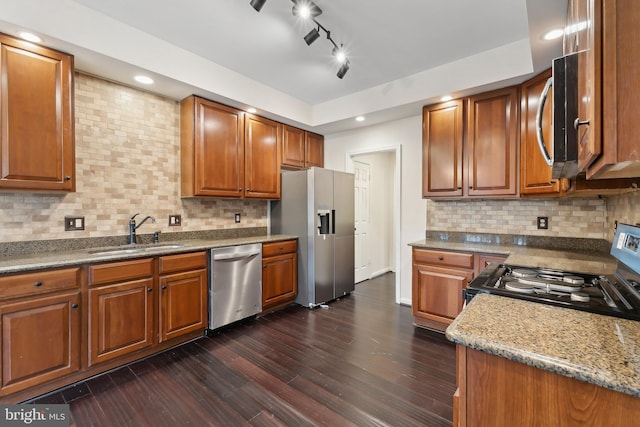 kitchen with sink, backsplash, stainless steel appliances, dark hardwood / wood-style floors, and stone countertops