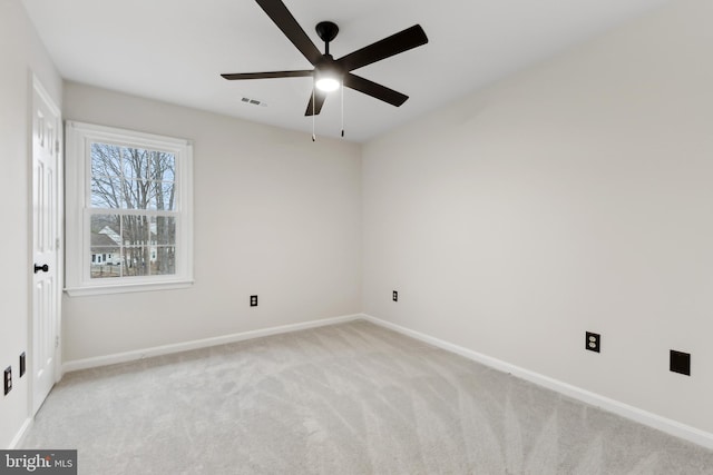 spare room featuring light colored carpet and ceiling fan