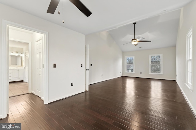 unfurnished living room featuring dark hardwood / wood-style flooring, vaulted ceiling, and ceiling fan