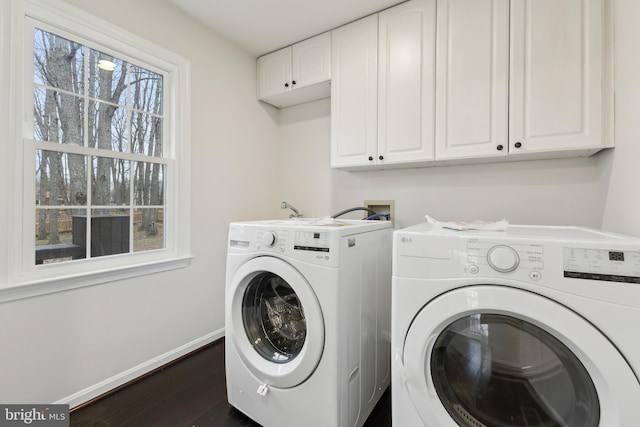 washroom with cabinets, a healthy amount of sunlight, dark wood-type flooring, and independent washer and dryer