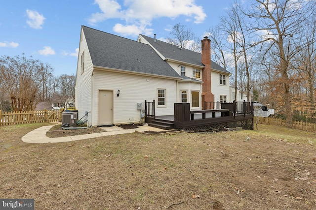 back of house featuring a wooden deck, central AC unit, and a yard