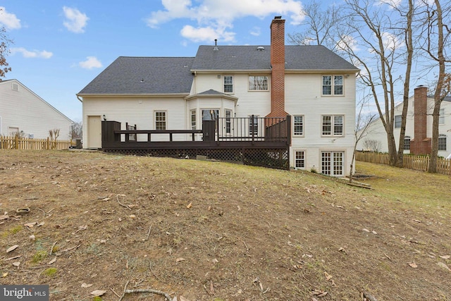 back of property with a wooden deck and a yard