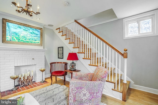 interior space with an inviting chandelier, hardwood / wood-style floors, and a brick fireplace