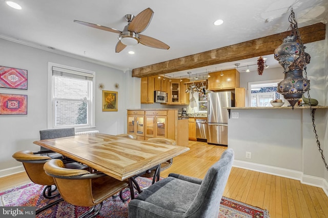 dining space with beam ceiling, ceiling fan, and light wood-type flooring