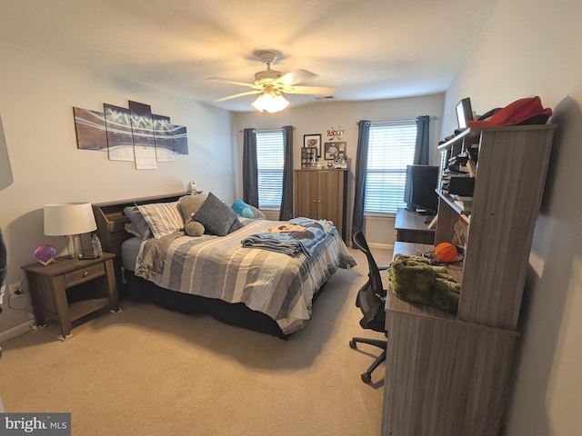 carpeted bedroom featuring a ceiling fan, visible vents, and baseboards