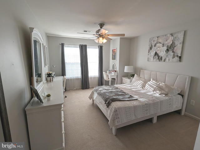 bedroom with a ceiling fan, light carpet, visible vents, and baseboards