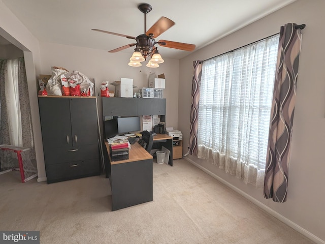 office space with light colored carpet, a wealth of natural light, and baseboards