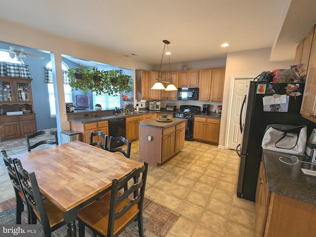 kitchen featuring black appliances, dark countertops, a kitchen island, and pendant lighting