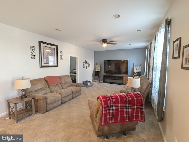 living room with a ceiling fan, visible vents, baseboards, and carpet flooring