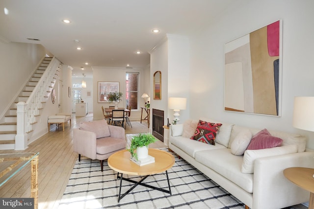 living room featuring ornamental molding and light hardwood / wood-style floors