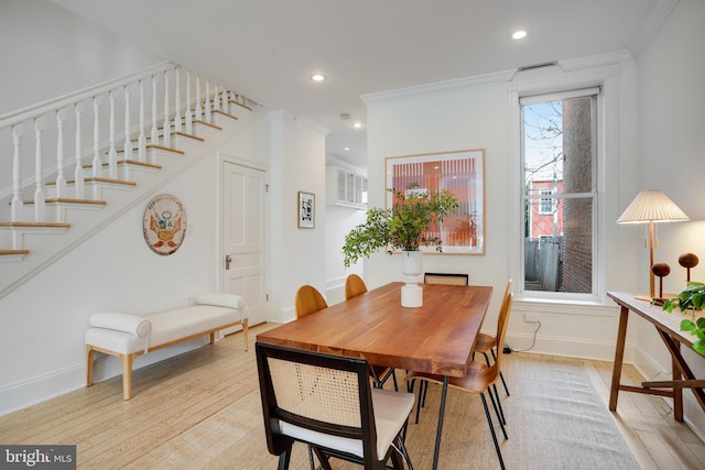 dining space with light hardwood / wood-style floors and ornamental molding